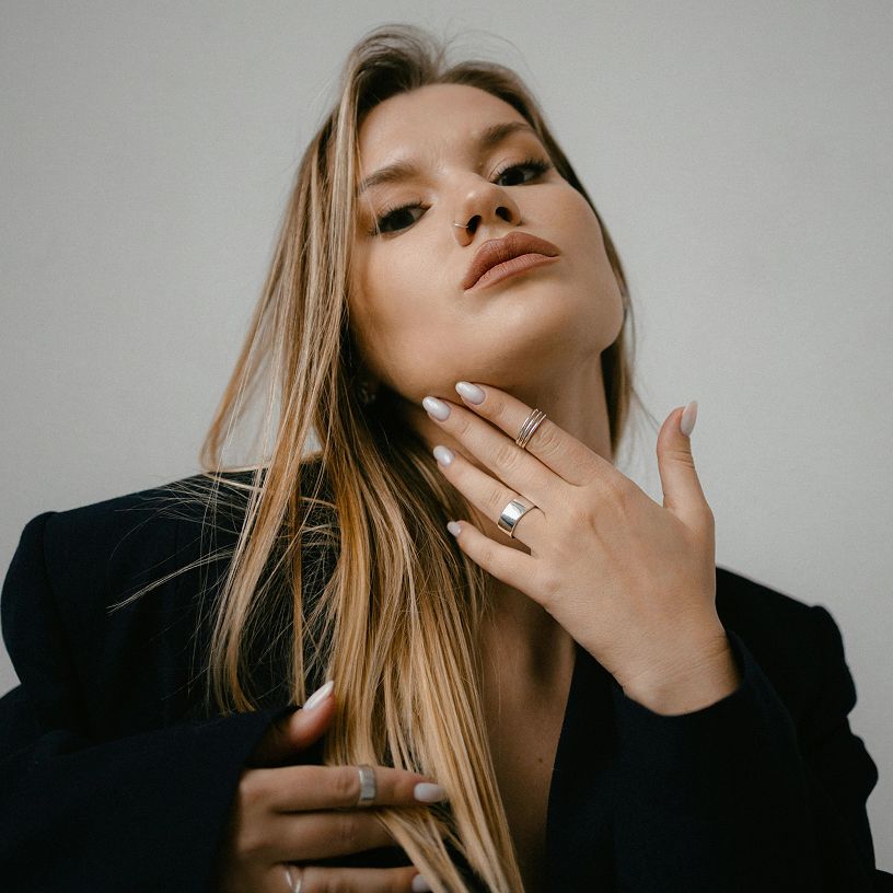 Woman showcasing jewelry with elegant pose.