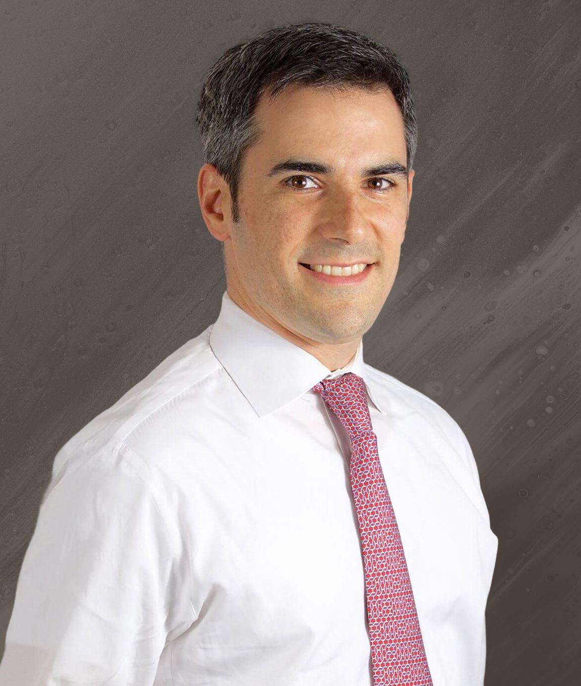 Professional man smiling in formal attire.