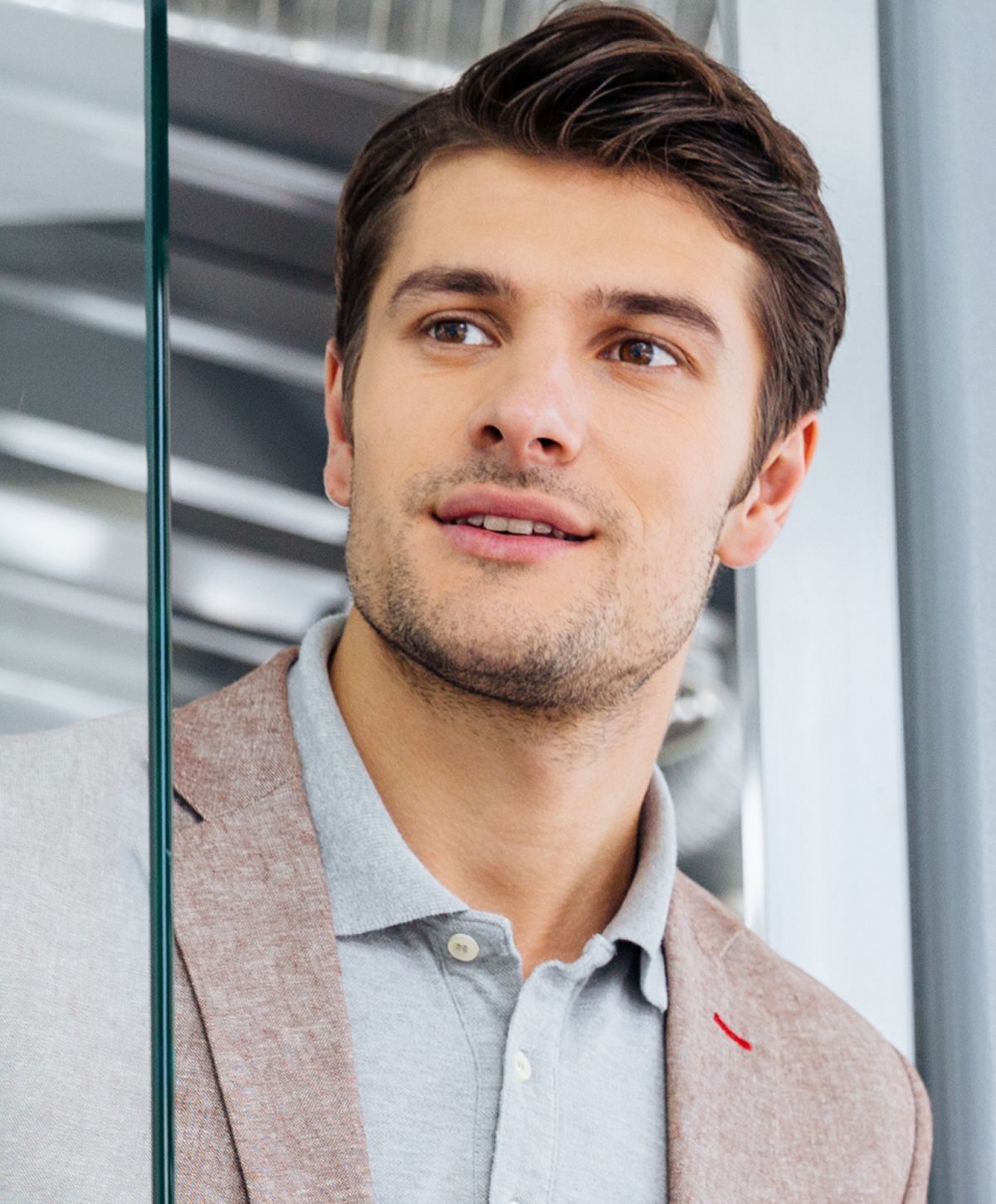 Smiling man in professional attire, looking thoughtfully.