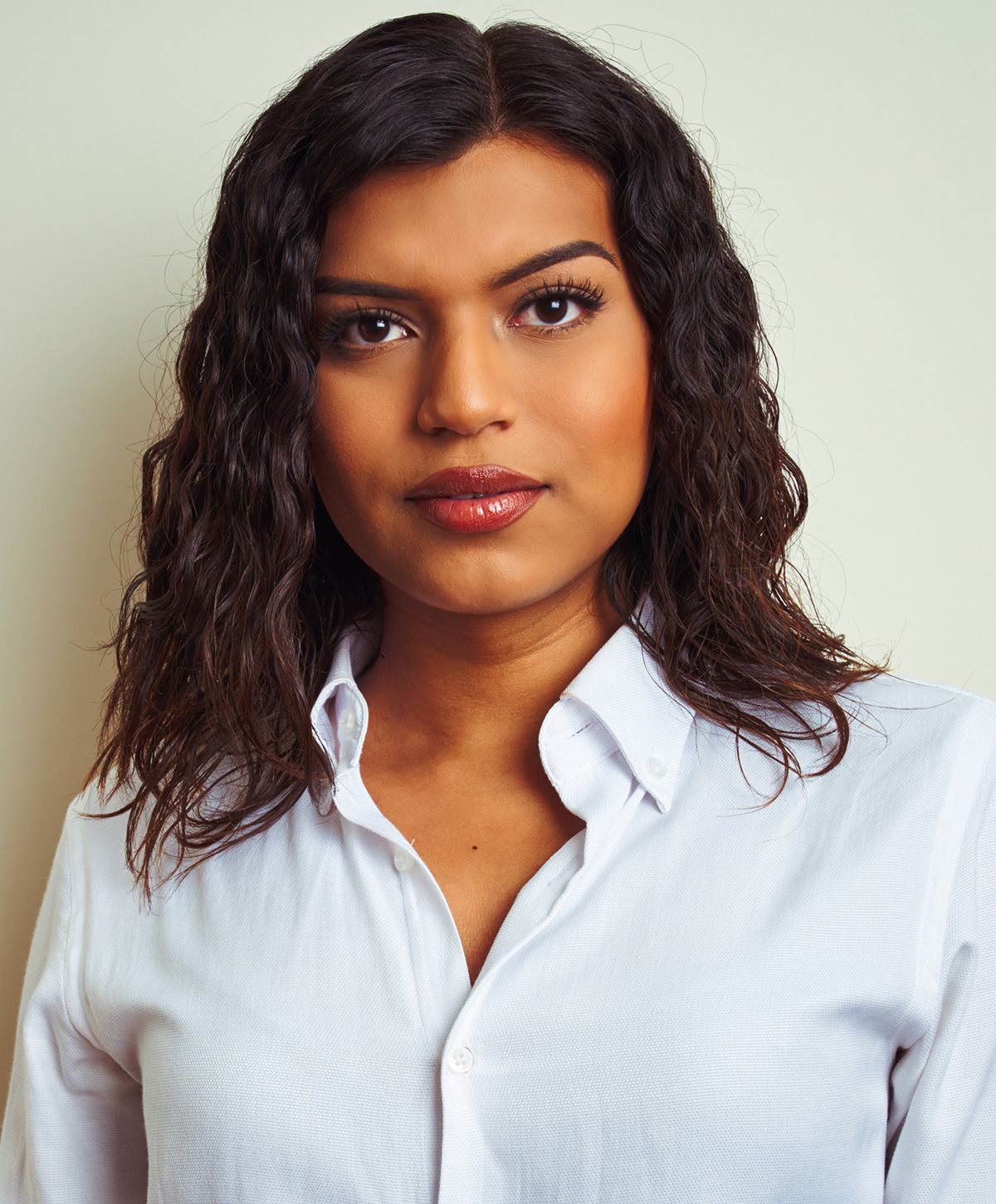 Person with curly hair wearing a white shirt.