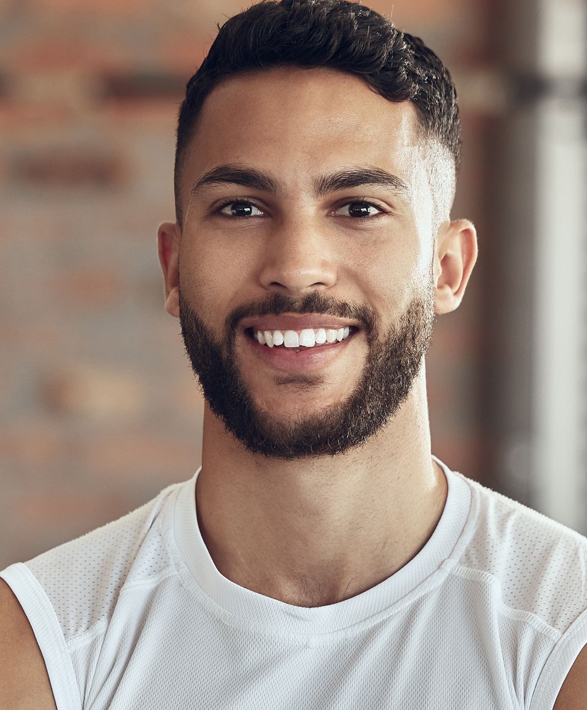 Smiling man with a beard in athletic wear.