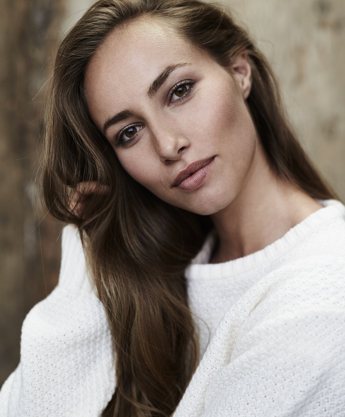 Woman with long hair in white sweater.