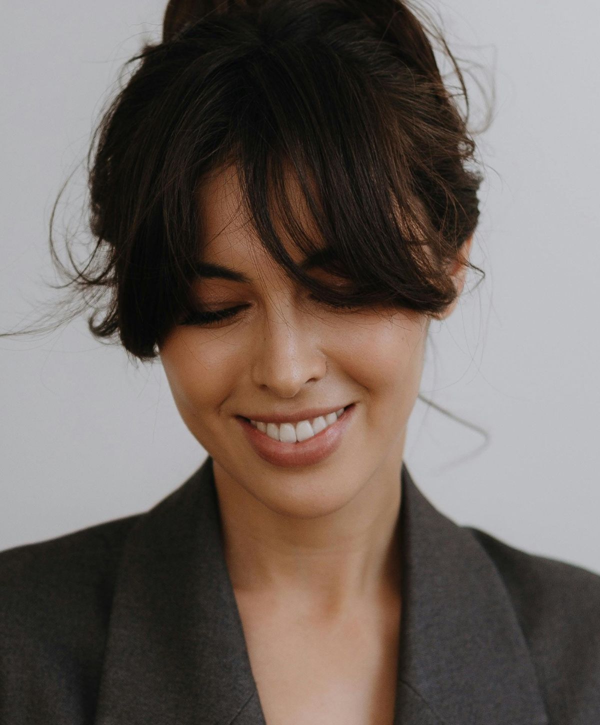 Smiling woman with soft hair and blazer.