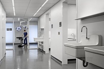 Modern surgical room with medical equipment and staff.