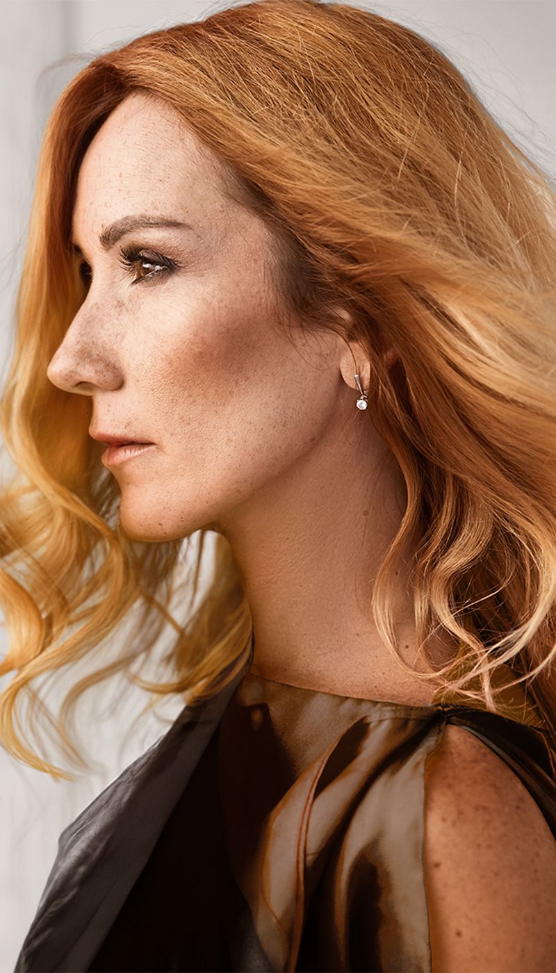 Profile of a woman with flowing red hair.