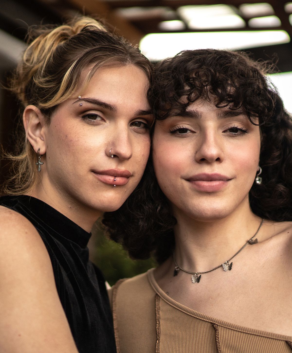 Two friends posing closely together, smiling.