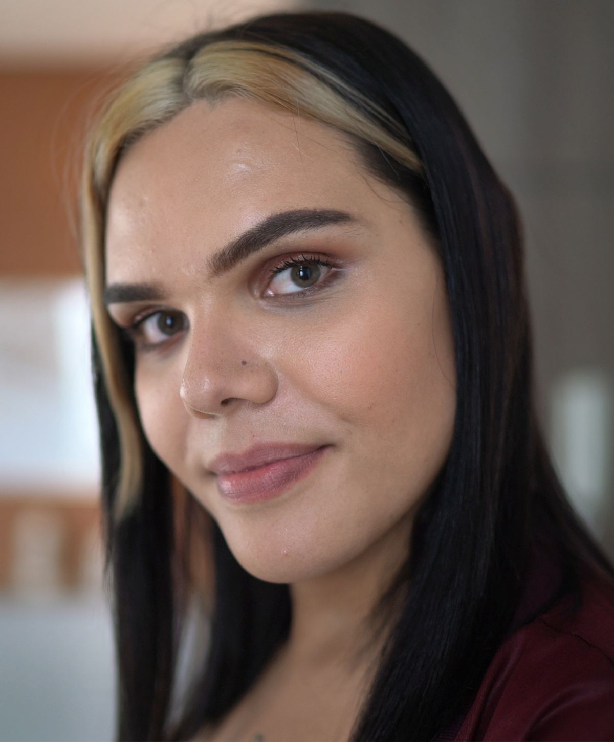 Close-up portrait of a person with two-tone hair.
