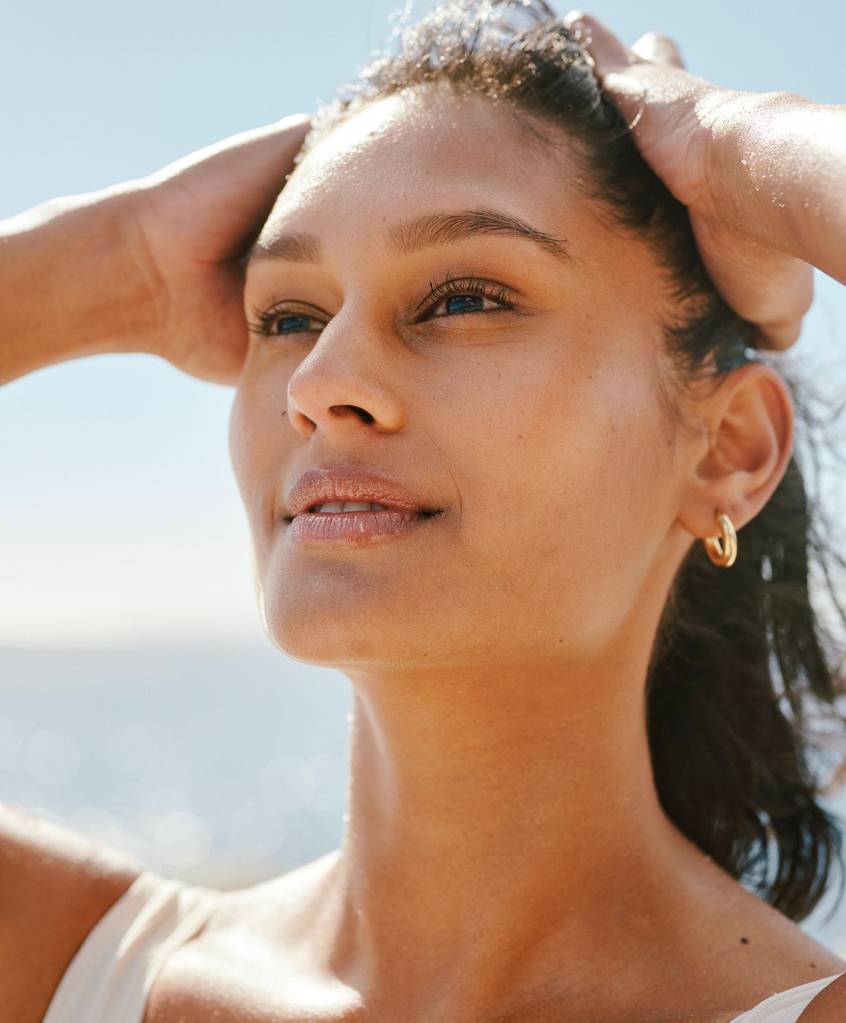 Smiling woman enjoying a sunny beach day.